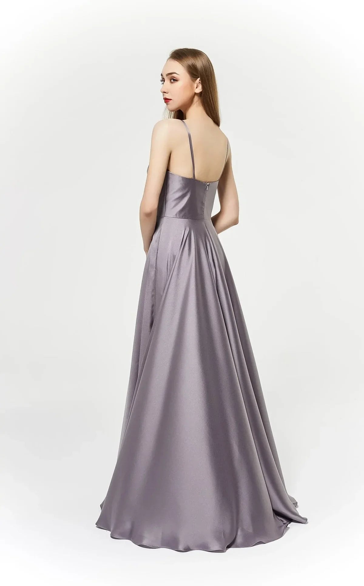 Elegant back view of a model in a satin J19025 ball gown featuring delicate straps and a flowing skirt.