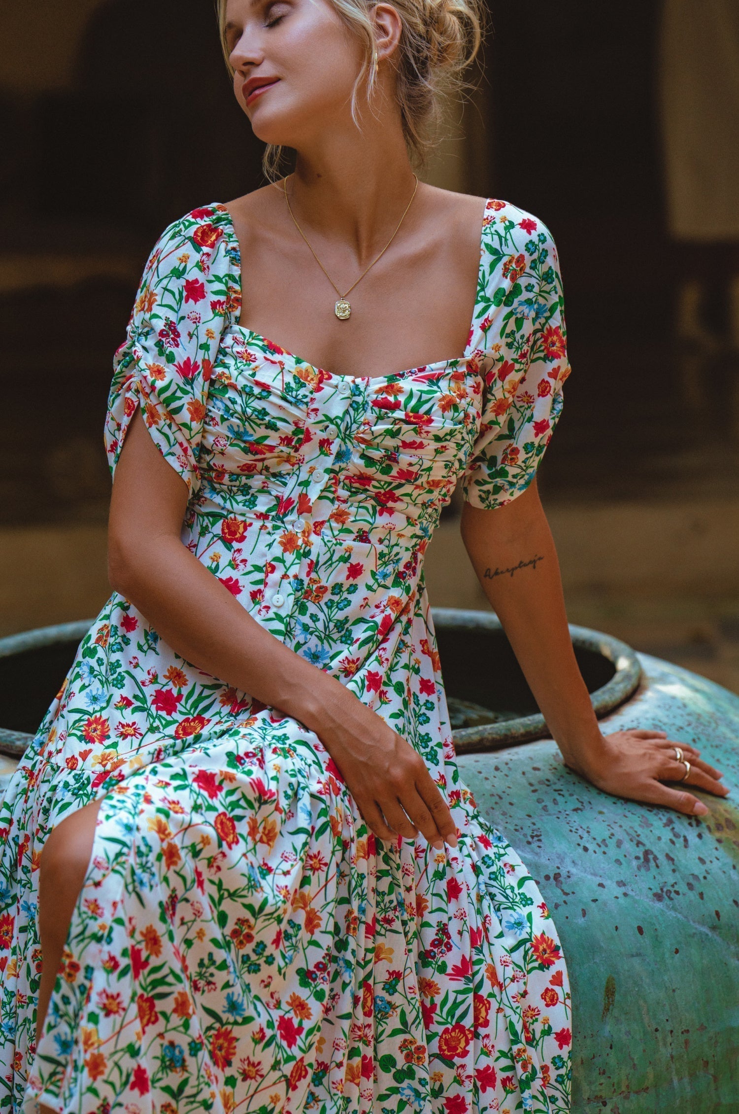 Woman wearing the Lilit Midi Dress with floral print, showcasing its relaxed and sophisticated style.