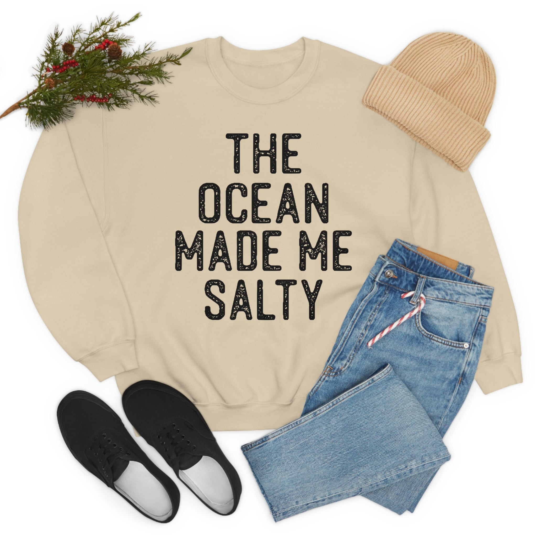 The Ocean Made Me Salty cream sweatshirt styled with denim jeans and black shoes for a cozy look.
