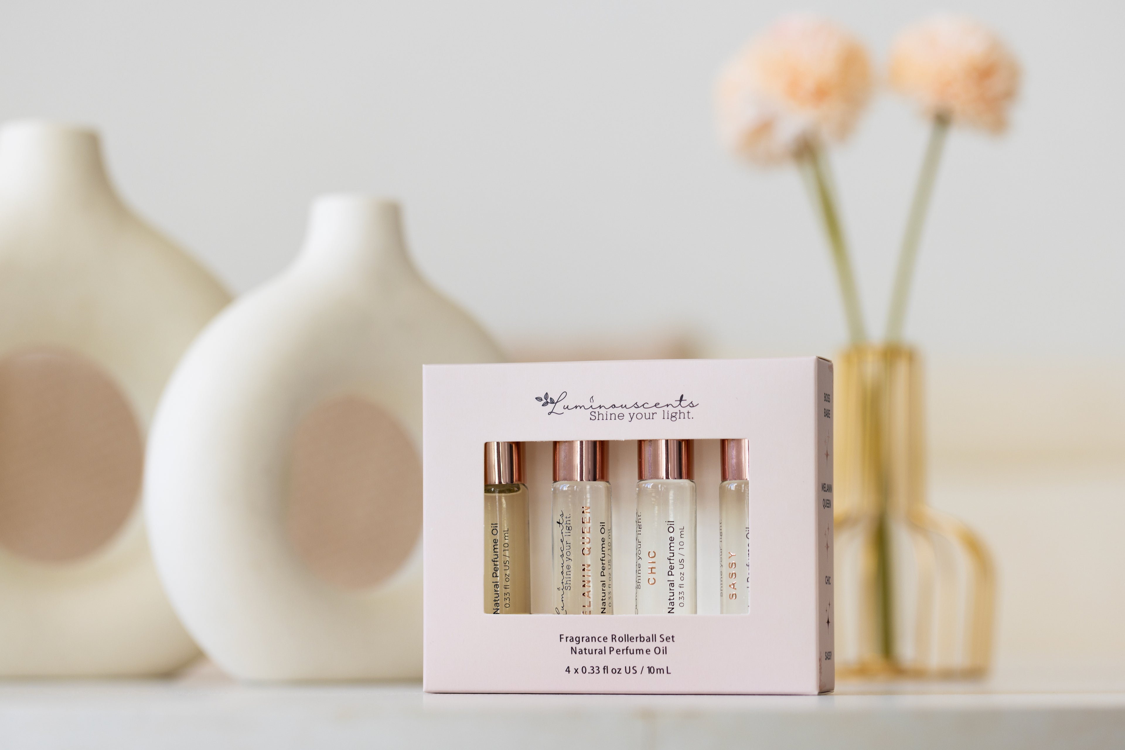 For Her Perfume Oil Roll-On set displayed with elegant vases and flowers, enhancing beauty and fragrance.