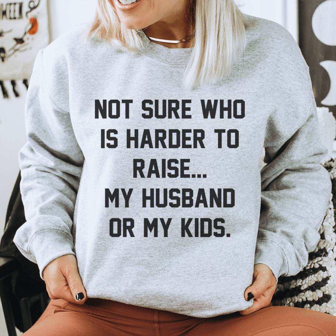 Not Sure Who Is Harder To Raise sweatshirt featuring humorous text about parenting, comfortable cotton/poly fleece blend.