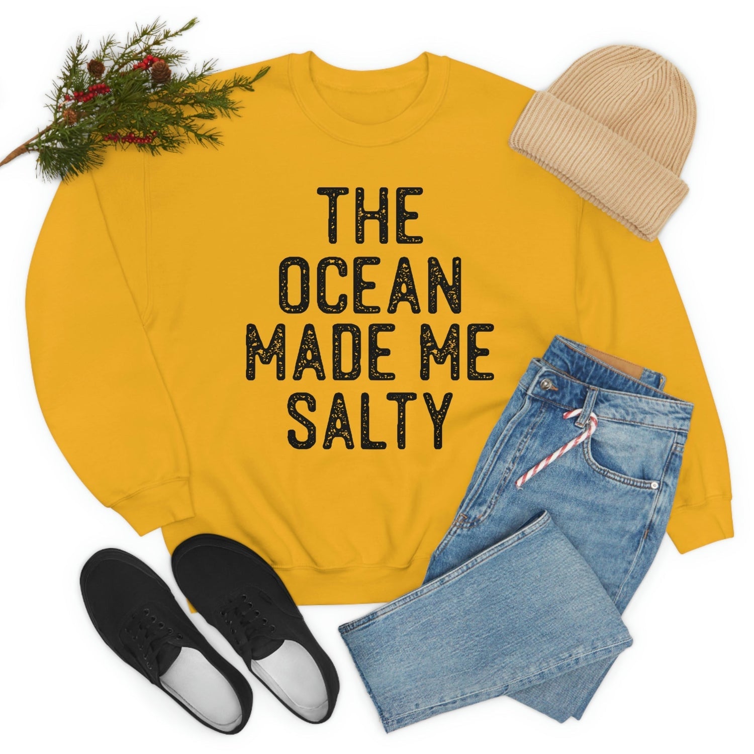The Ocean Made Me Salty sweatshirt in yellow, styled with jeans and a beanie for a fashionable look.