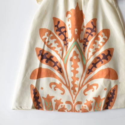 Tropical Isla Girls Linen Dress featuring vibrant floral print in orange and turquoise on lightweight fabric.