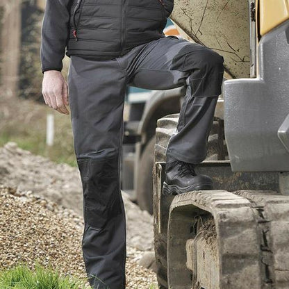 Mens Tuffstuff Excel Work Trousers - 710 worn by a worker, featuring Tuff-Tex reinforcement and knee pad pockets.
