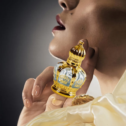 Roller Perfume Oil Long Lasting Floral Fragrance in an elegant gold crown bottle held by a model.