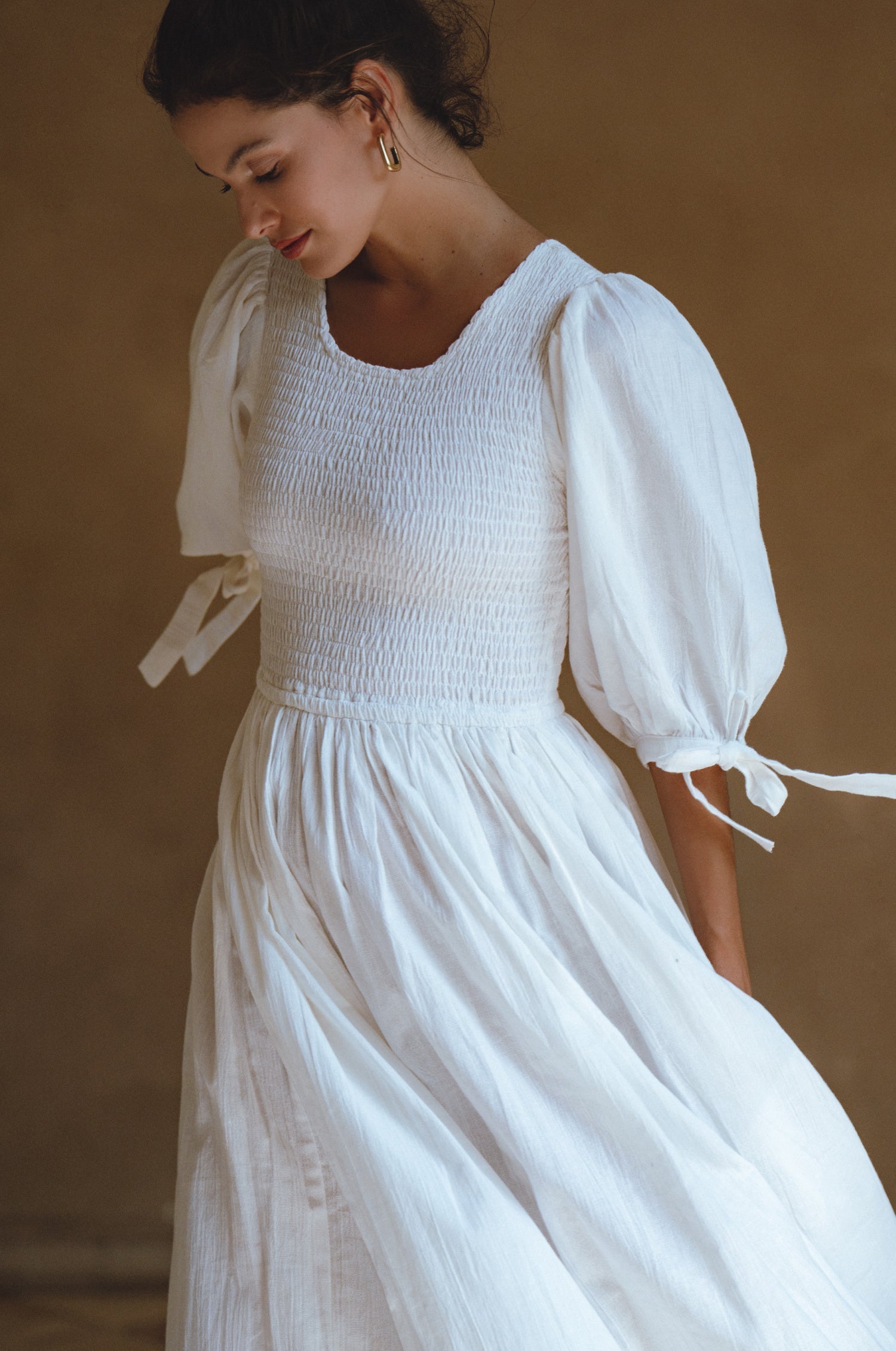 Freya Smocked Linen Midi Dress featuring smocked bodice and tie-up puff sleeves in crinkle linen.