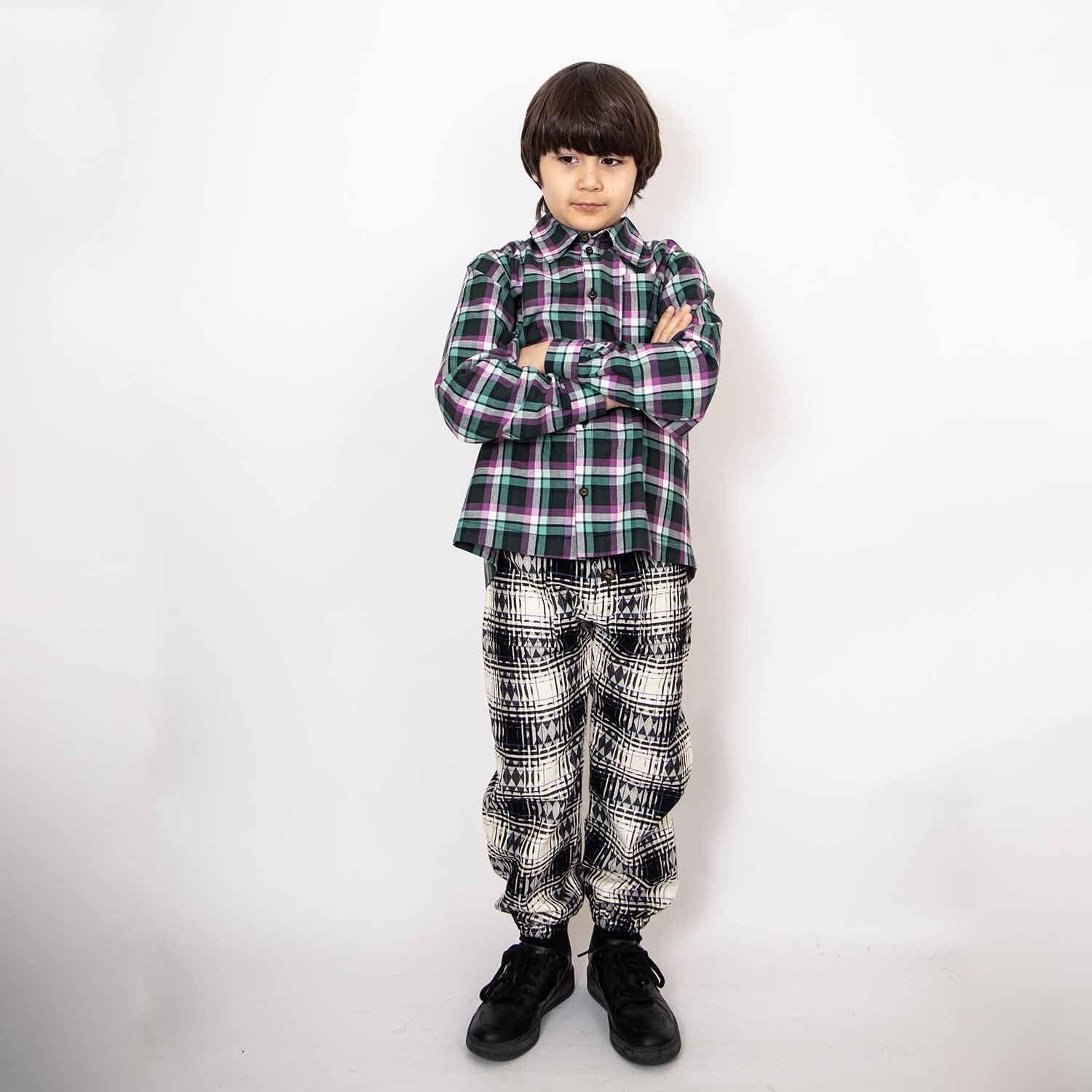 Kids Pants in Black &amp; White Tartan worn by a child, featuring a modern wide-leg silhouette and stylish pattern.