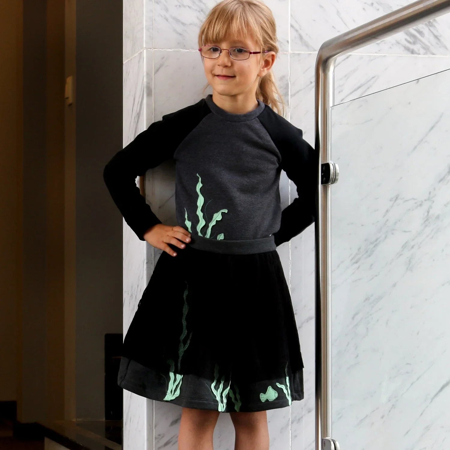 Sweatshirt with Marine Application worn by a girl, featuring playful marine motifs and stylish black skirt.