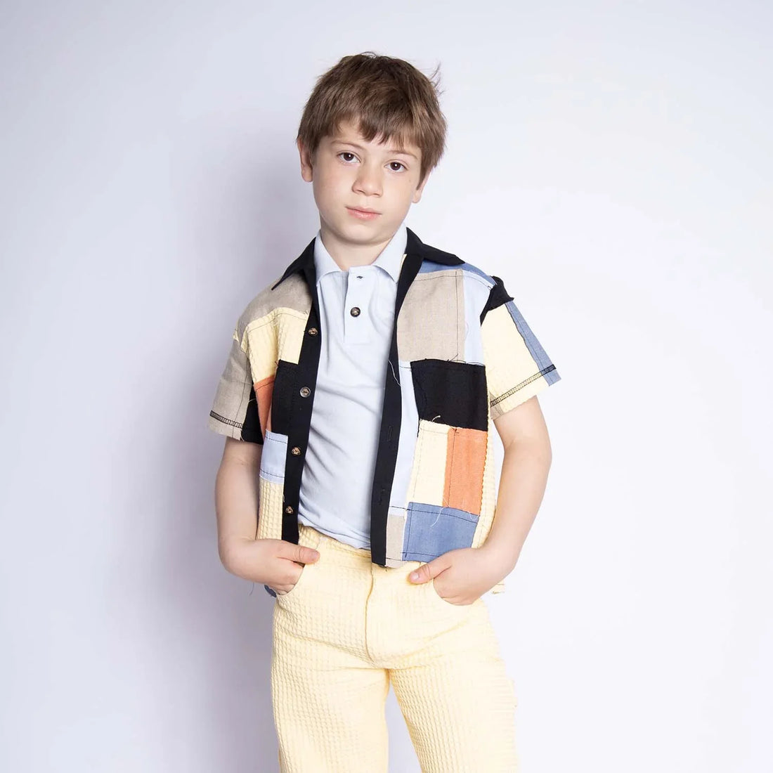 Kids Shirt Zero Waste Patchwork Shirt for Kids worn by a boy, showcasing colorful patchwork and short sleeves.