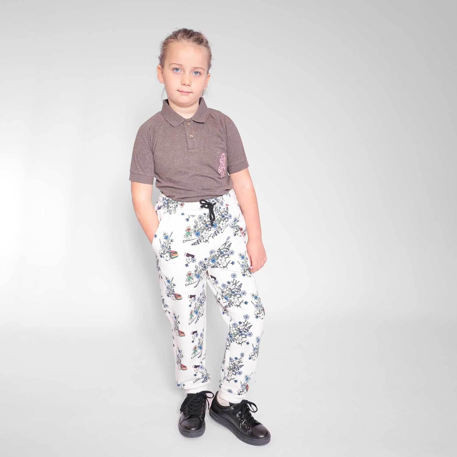 organic cotton kids sweatpants Kids Sweatpants in White Print featuring a child styled casually, showcasing a blend of comfort and playful elegance.