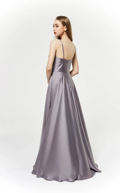 Elegant back view of a model in a satin J19025 ball gown featuring delicate straps and a flowing skirt.
