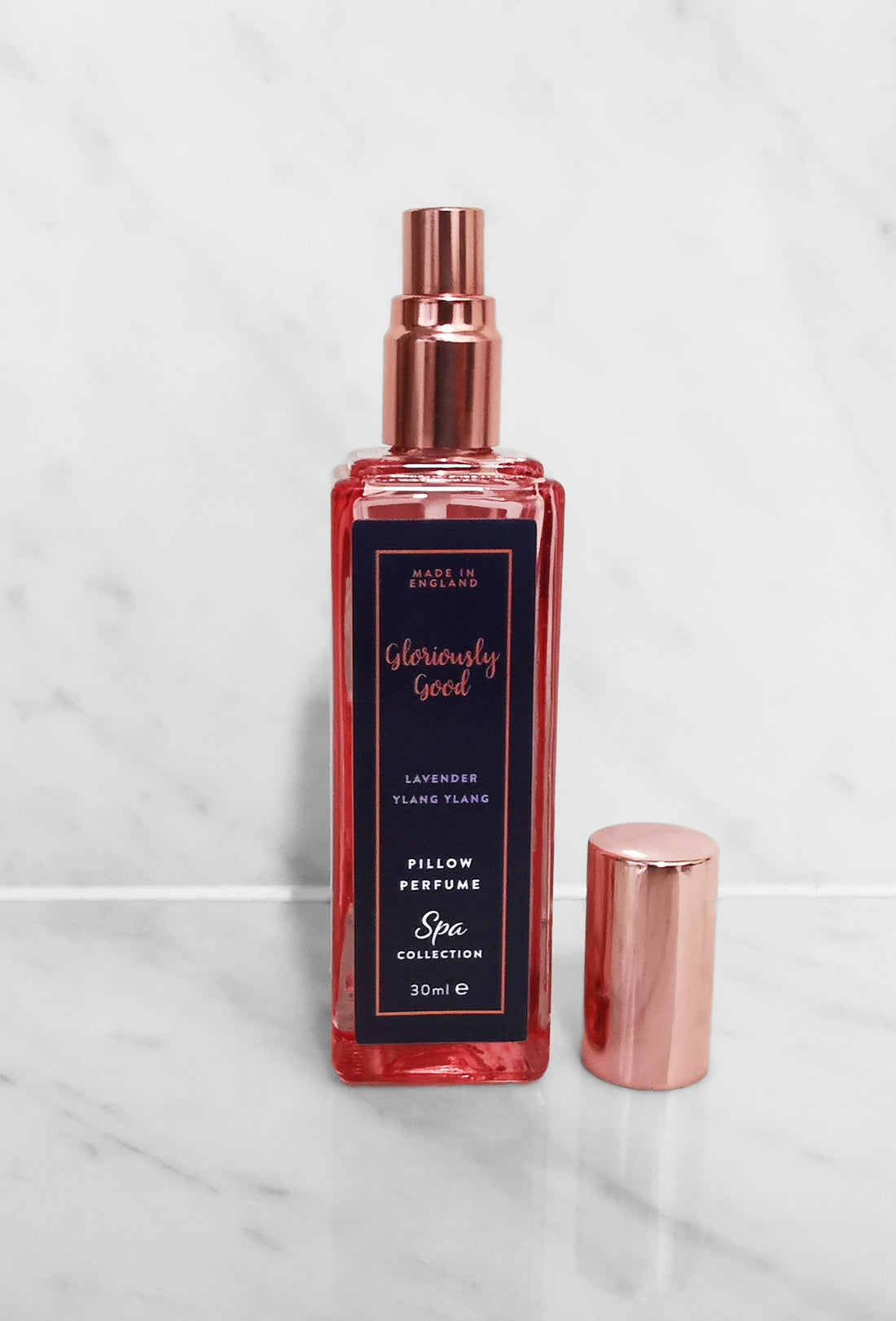Lavender &amp; Ylang Ylang Pillow Perfume Mist in a stylish spray bottle on a marble background.