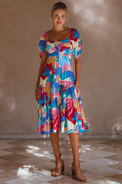 Lilit Midi Dress featuring puff sleeves and vibrant floral patterns, perfect for casual outings or relaxing at home.