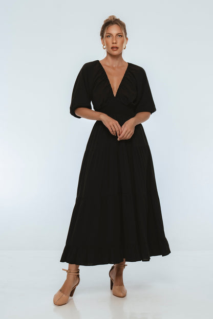 Lucienne Smocked Linen Maxi Dress worn by model showcasing deep V neckline and puff sleeves