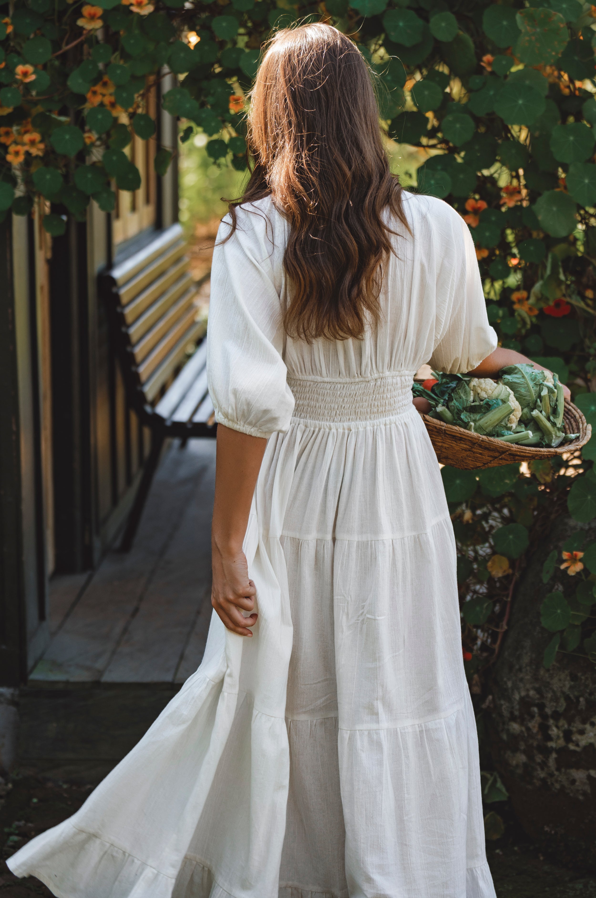 Lucienne Smocked Linen Maxi Dress worn by a woman with a basket, showcasing its elegant design and puff sleeves.