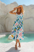 Model wears the Sea Dreamer Strappy Midi Dress featuring a vibrant print, perfect for summer beachside events.