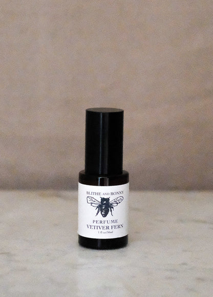 Petite Perfume Vetiver Fern 1.1oz bottle on marble surface with black spray top and simple label design.