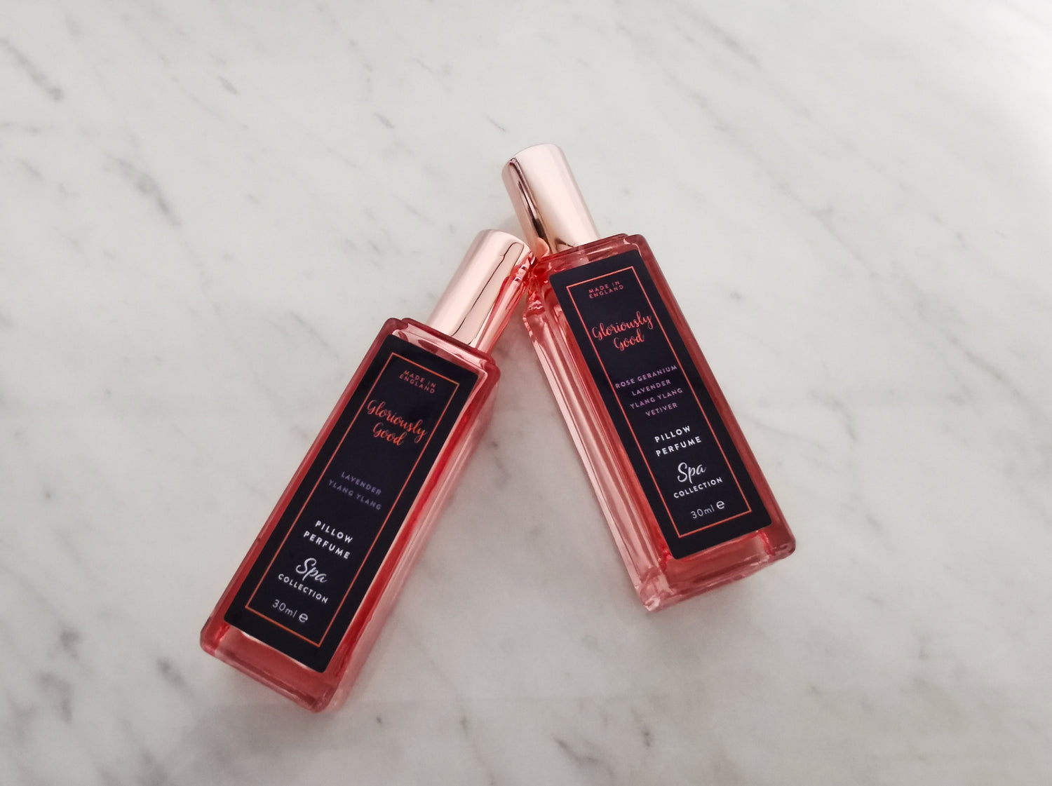 Lavender &amp; Ylang Ylang Pillow Perfume Mist bottles on a marble surface, perfect for promoting peaceful sleep.