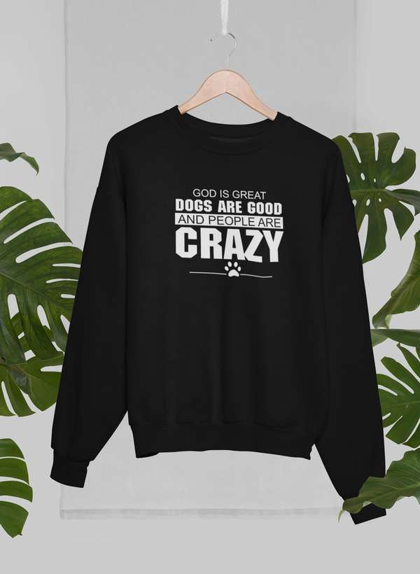 God Is Great Dogs Are Good And People Are Crazy Sweat Shirt displayed on a hanger with tropical foliage.