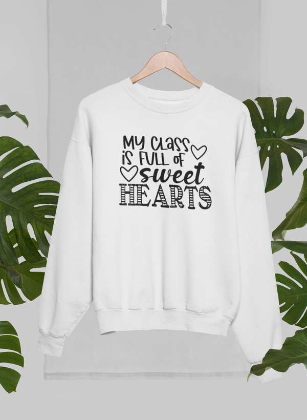 My Class Is Full Of Sweet Hearts Sweat Shirt displayed on a hanger with tropical leaves in the background.