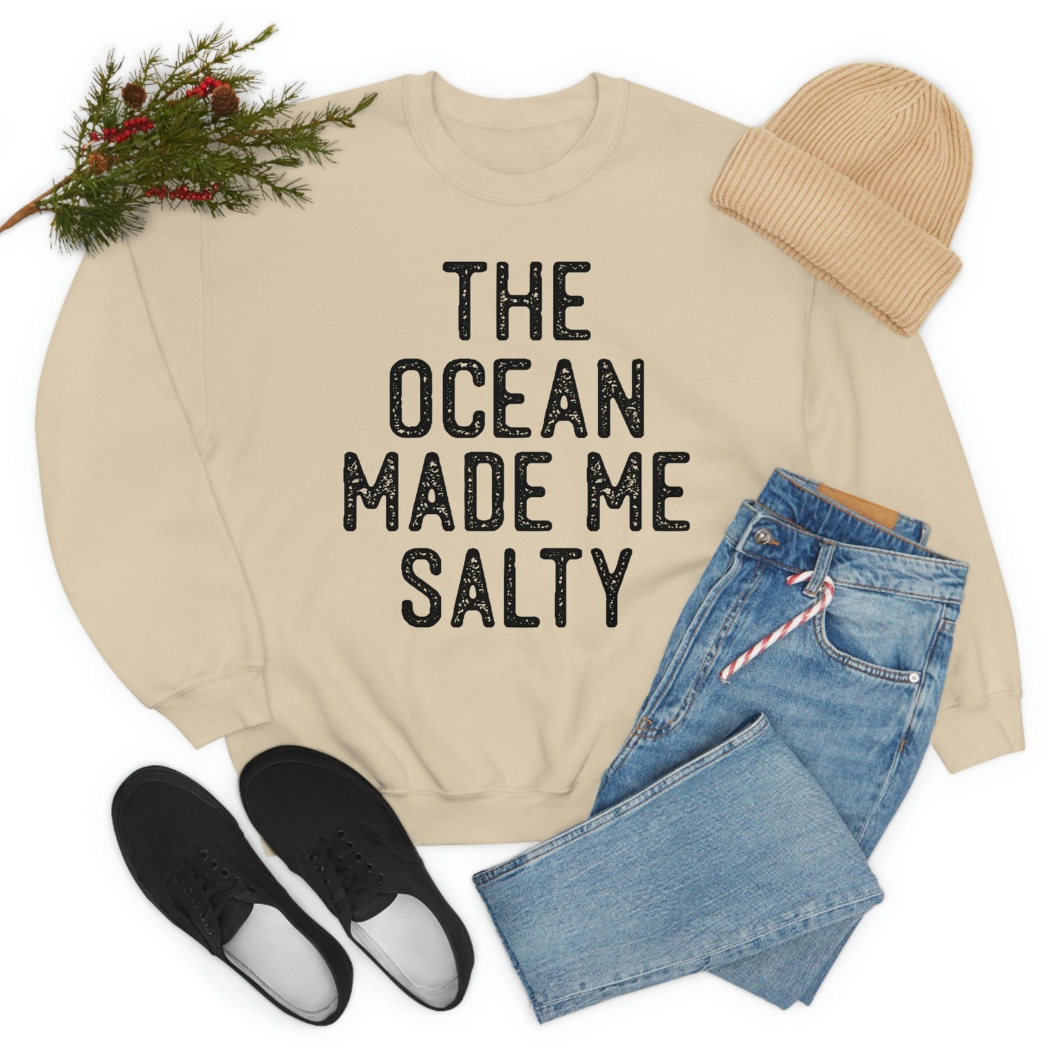 The Ocean Made Me Salty cream sweatshirt styled with denim jeans and black shoes for a cozy look.