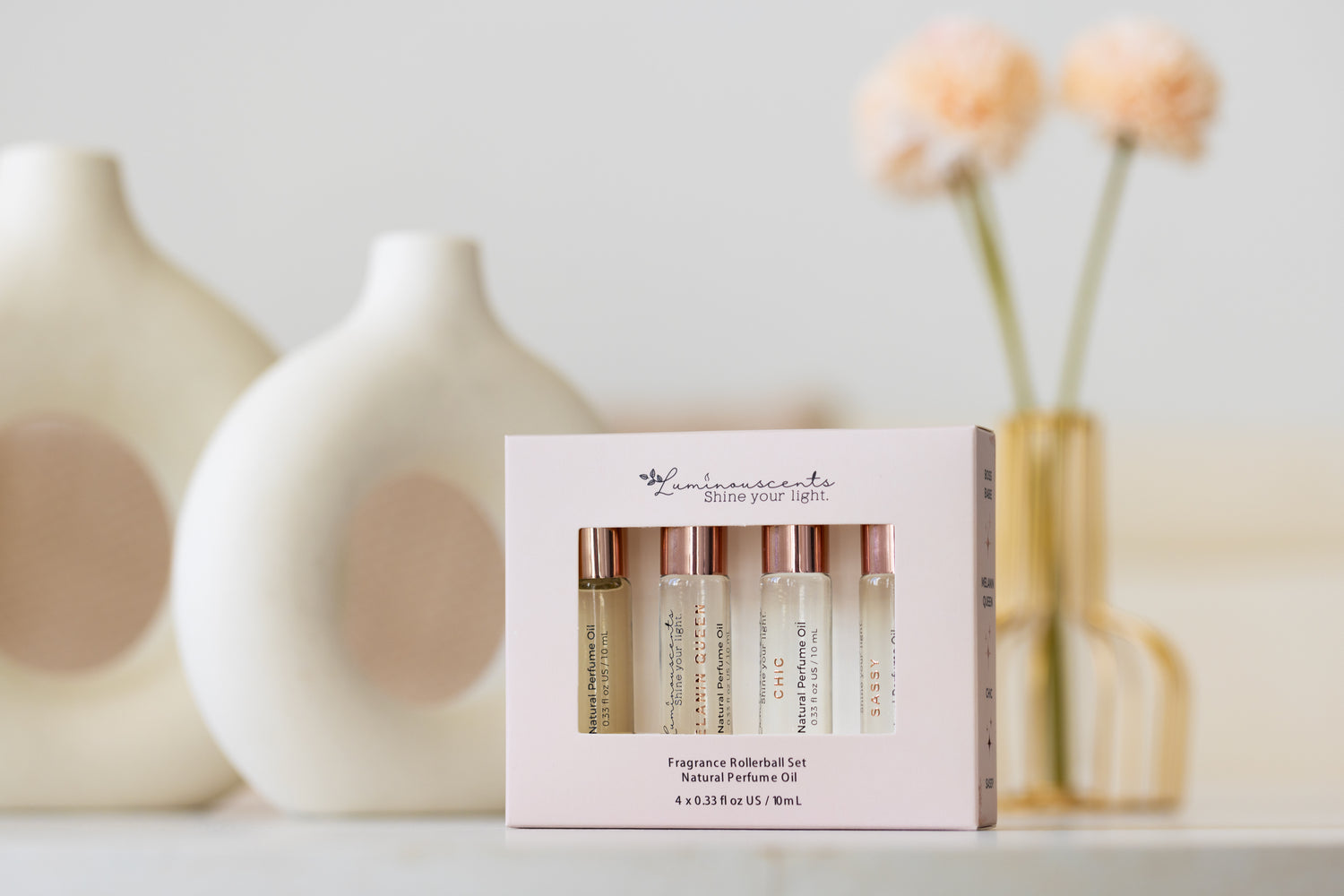For Her Perfume Oil Roll-On set displayed with elegant vases and flowers, enhancing beauty and fragrance.