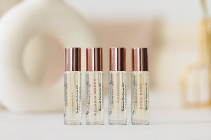 For Her" Perfume Oil Roll-On in elegant glass vials with rose gold caps, highlighting signature fragrances for empowered women.