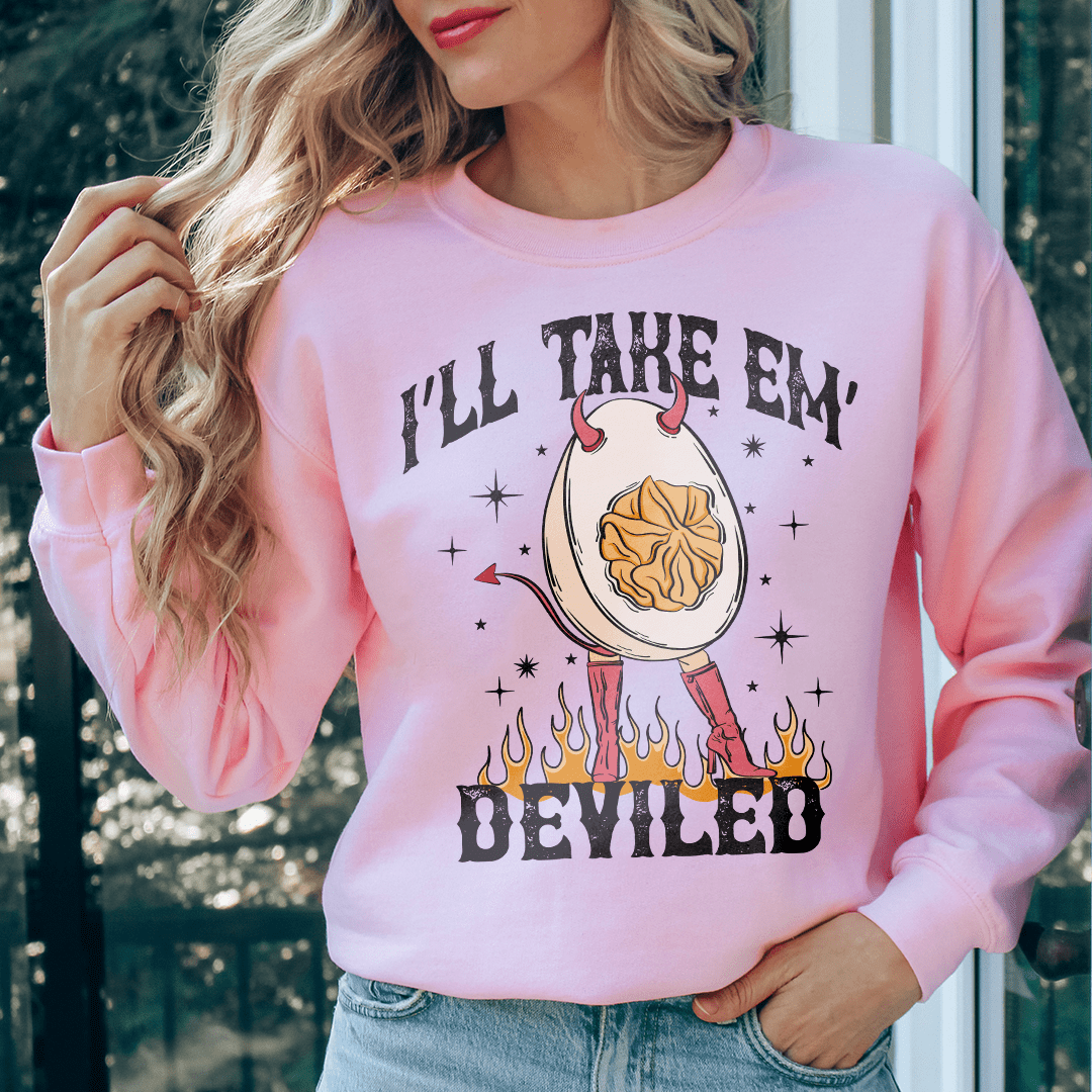 A woman wearing a pink sweatshirt featuring the graphic "I&