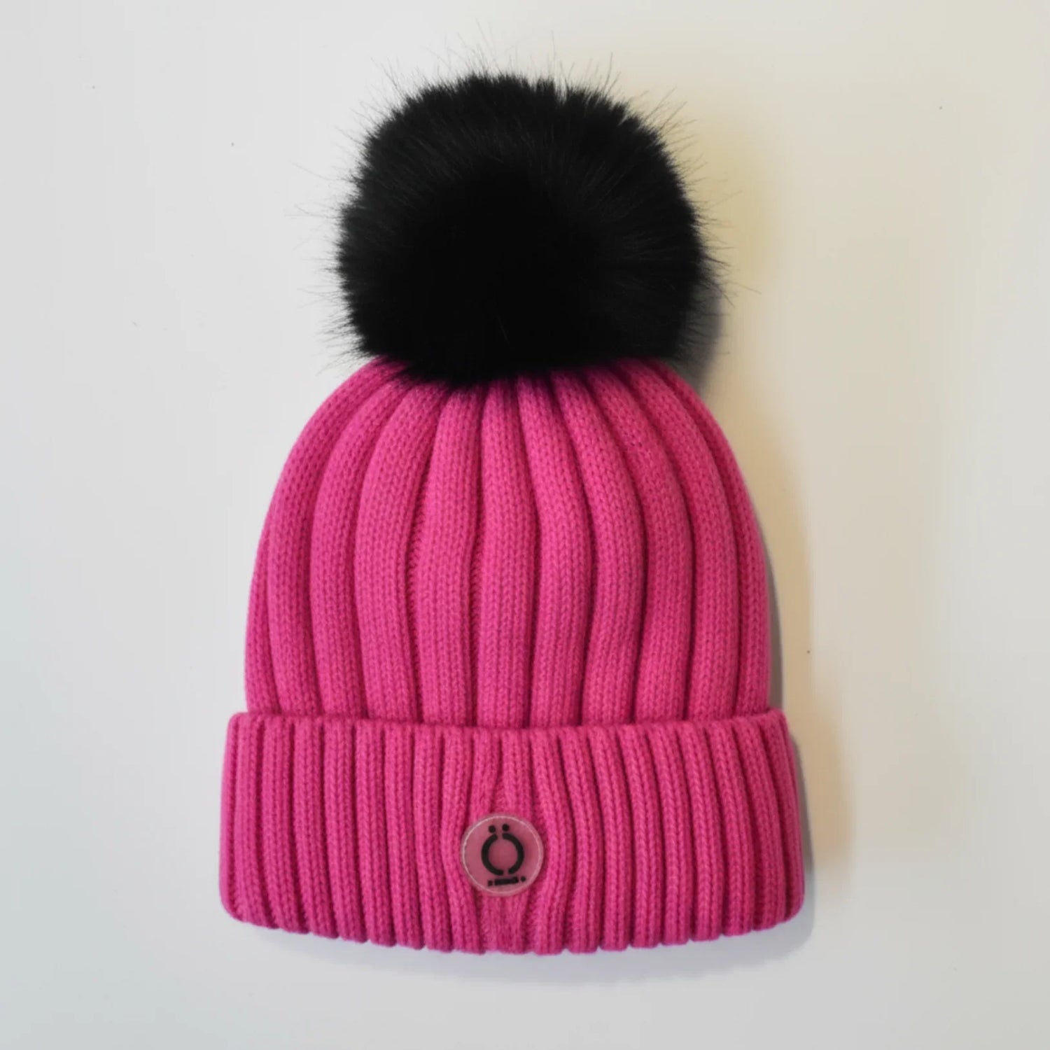 Fushia Tuque with removable black fur pompom and soft polar fleece lining, perfect for winter fashion.