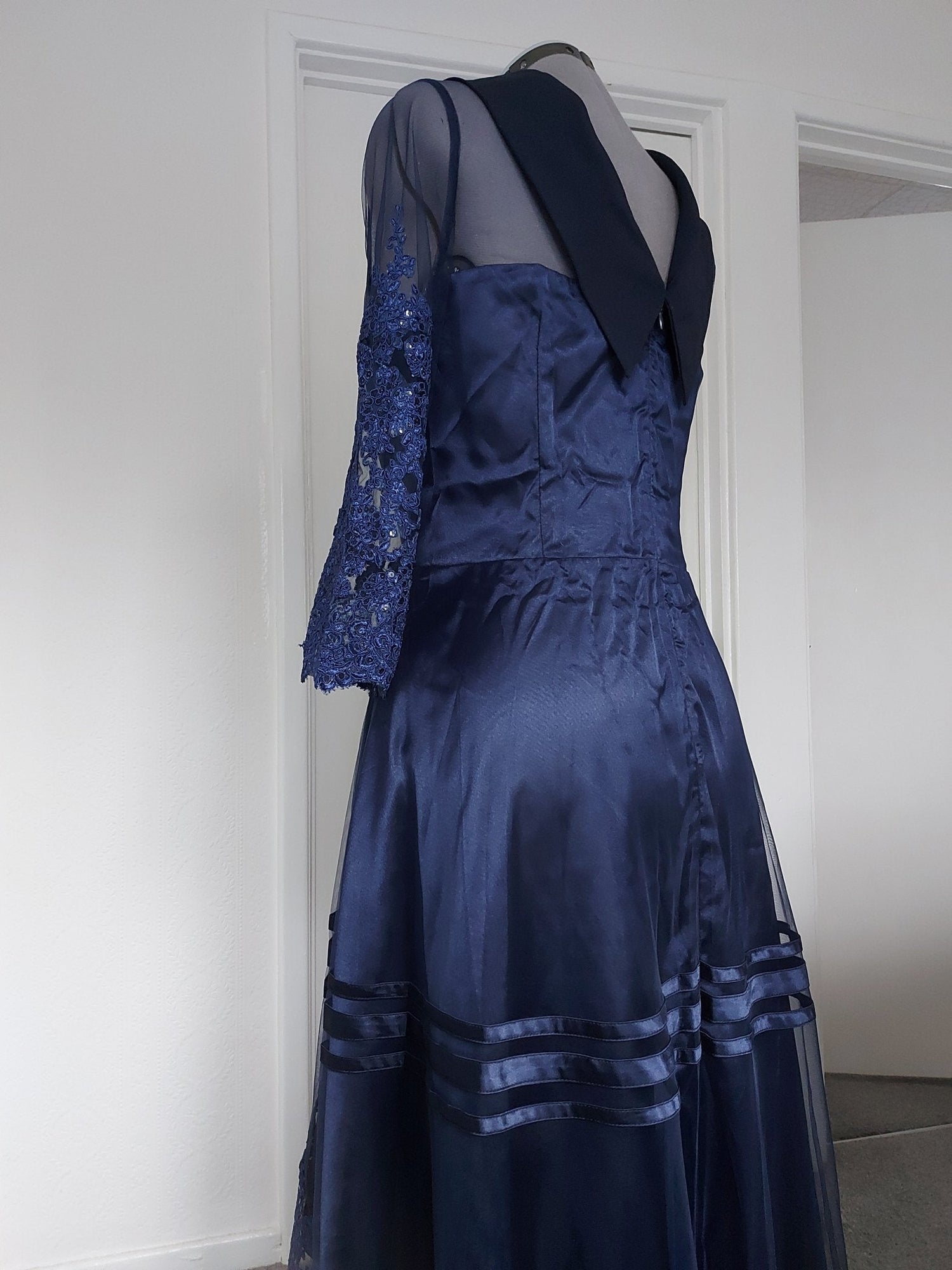 The midnight fold collar high-low mum dress showcasing elegant navy fabric and intricate lace sleeve details.