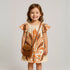 Tropical Isla Girls Linen Dress on a smiling girl featuring floral patterns and puffed sleeves.