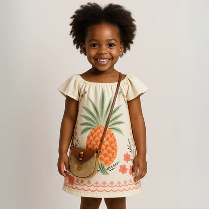 Tropical Isla Girls Linen Dress featuring a child in a pineapple printed dress with a cute bag.